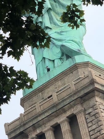 A protester is seen on the Statue of Liberty in New York, New York, U.S., July 4, 2018 in this picture obtained from social media. Danny Owens/via REUTERS