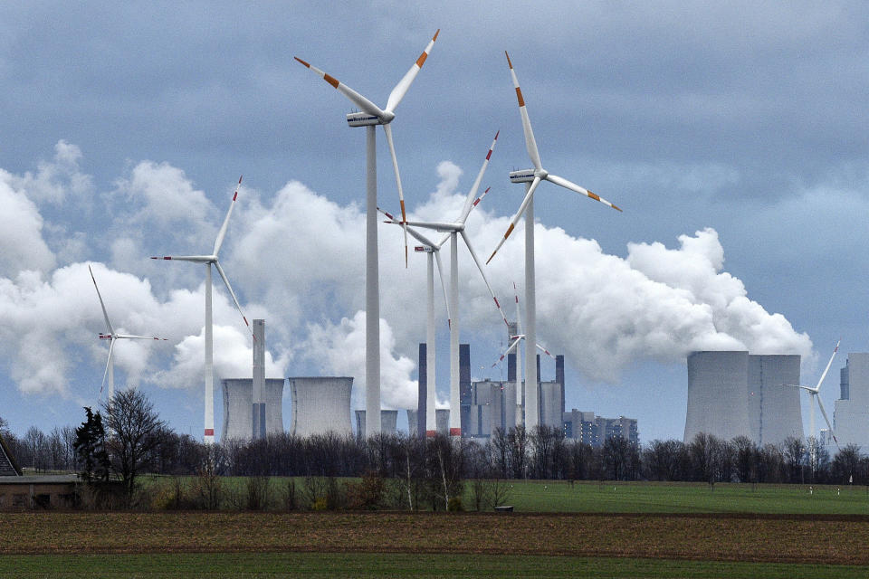 FILE - Wind turbines are seen in front of a coal fired power plant near Jackerath, Germany on Friday, Dec. 7, 2018. With climate change, plastic pollution and a potential sixth mass extinction, humanity has made some incredible messes in the world. But when people, political factions and nations have pulled together, they have also cleaned up some of those human-caused environmental problems. (AP Photo/Martin Meissner, File)