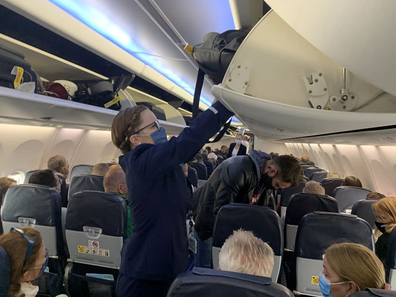 Las azafatas de TUI Fly usan mascarillas mientras dan instrucciones a los turistas alemanes en el primer vuelo de Dusseldorf a Mallorca en Dusseldorf, Alemania, el 15 de junio de 2020