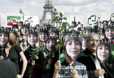 In this 2009 photo in Paris, people hold placards bearing images of Iranian Neda Agha-Soltan during a protest. AP Photo/Jacques Brinon, File)