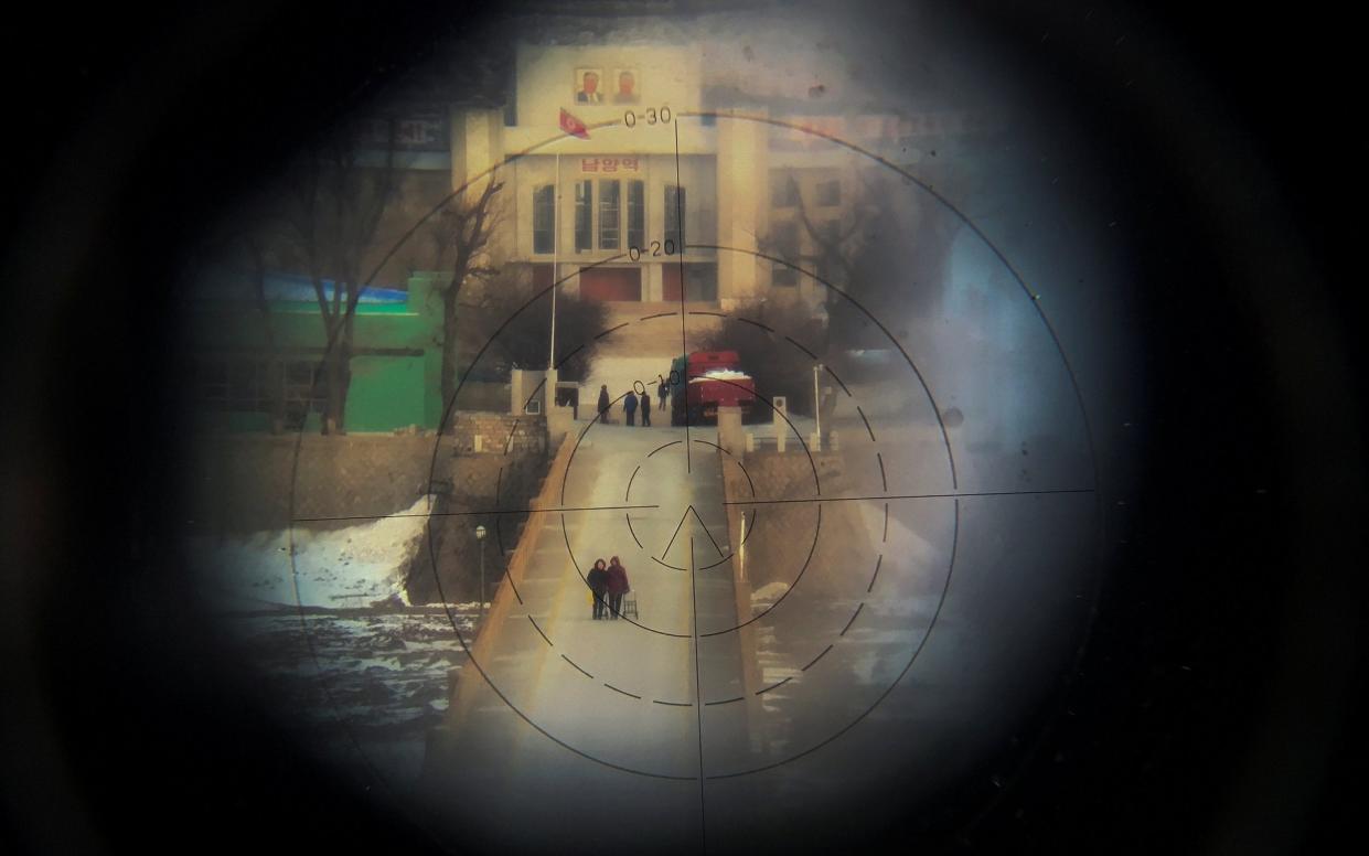 Women cross from North Korea into China, seen from the Chinese side of the border. - DAMIR SAGOLJ/REUTERS