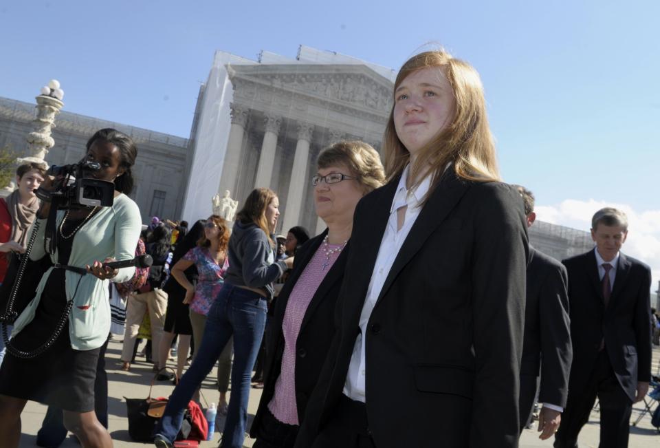 FILE - Abigail Fisher, right, who sued the University of Texas, walks outside the Supreme Court in Washington, Oct. 10, 2012. Fisher, who is white, sued after being rejected in 2008 from the University of Texas at Austin. She argued the university's policy discriminated against her because of race, in violation of the Constitution. (AP Photo/Susan Walsh, File)