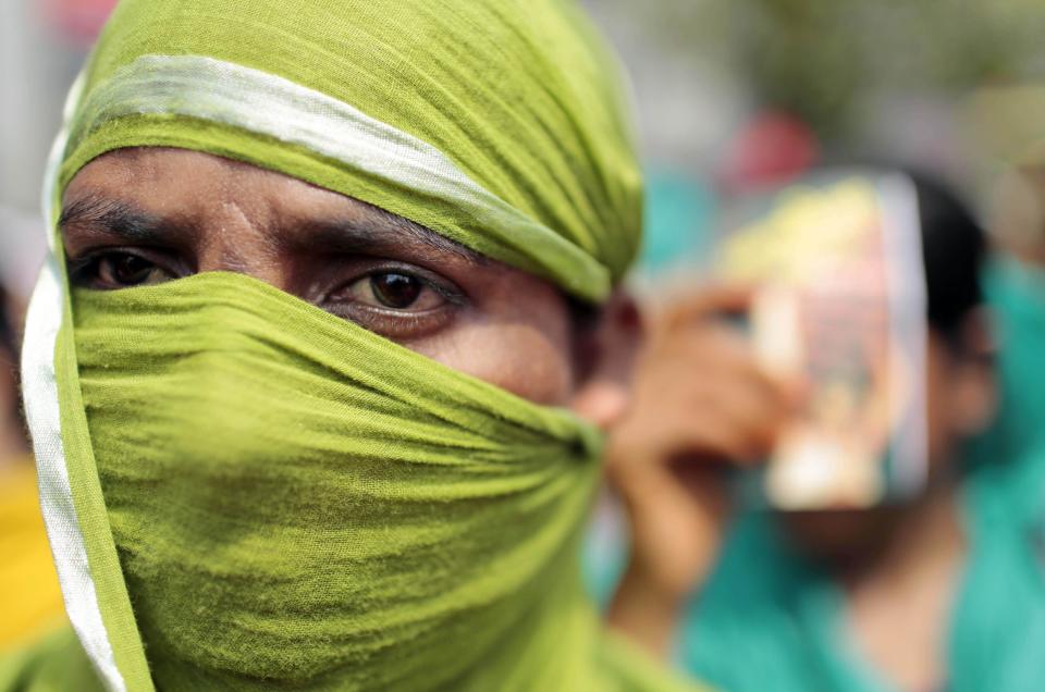 A Bangladeshi garment worker covers her face with a scarf to shelter herself from the sun as she participates in a May Day rally in Dhaka, Bangladesh, Thursday, May 1, 2014. The demonstrators demanded punishment for owners of garment factories that have had accidents in the past, compensation for victims and ensuring work place safety. (AP Photo/A.M. Ahad)