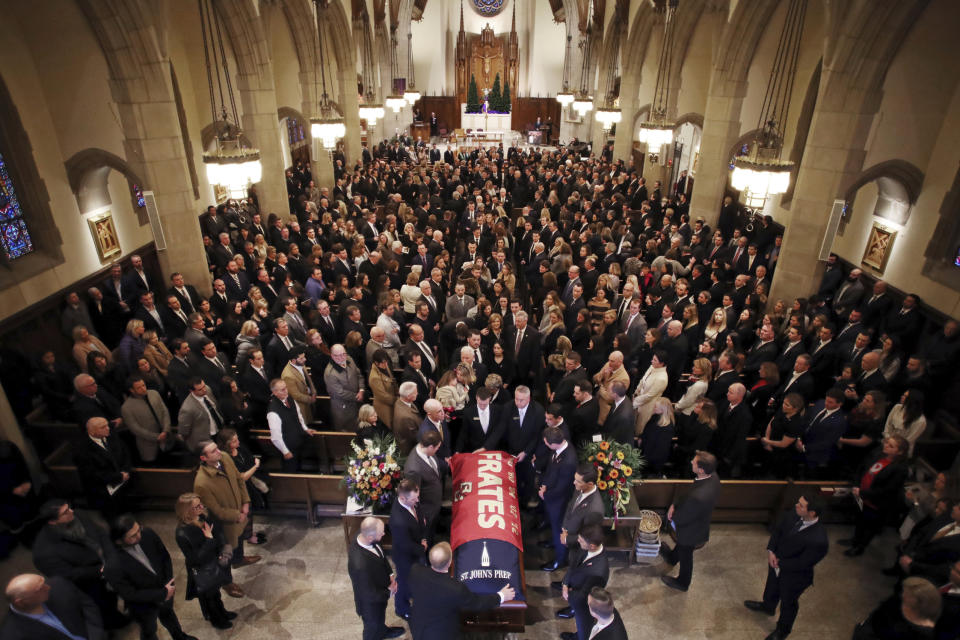 The procession follows the casket of Pete Frates, draped in a flag bearing his name, during a funeral mass at St. Ignatius of Loyola Parish church at Boston College in Boston, Friday, Dec. 13, 2019. Frates, a former college baseball player whose determined battle with Lou Gehrig's disease helped inspire the ALS ice bucket challenge that has raised more than $200 million worldwide. (Craig F. Walker/The Boston Globe via AP, Pool)