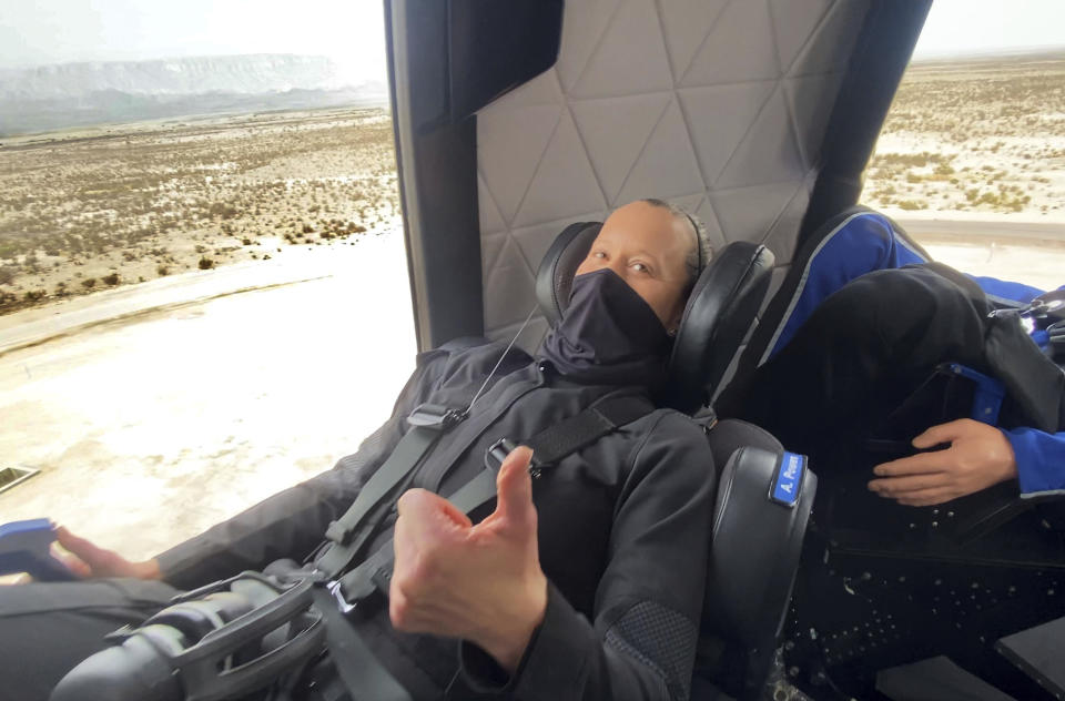 In this photo made available by Blue Origin, Audrey Powers gives a thumbs up inside the New Shepard rocket capsule during a crew rehearsal in West Texas on Wednesday, April 14, 2021. Two employees were strapped into the fueled rocketship for practice, but they disembarked shortly before the capsule launched to the edge of space with only a test dummy. (Blue Origin via AP)