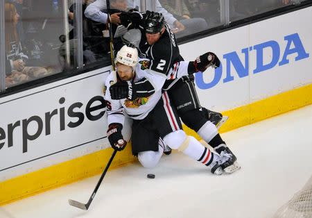 May 24, 2014; Los Angeles, CA, USA; Los Angeles Kings defenseman Matt Greene (2) hits Chicago Blackhawks center Michal Handzus (26) along the boards in game three of the Western Conference Final of the 2014 Stanley Cup Playoffs at Staples Center. Mandatory Credit: Gary A. Vasquez-USA TODAY Sports