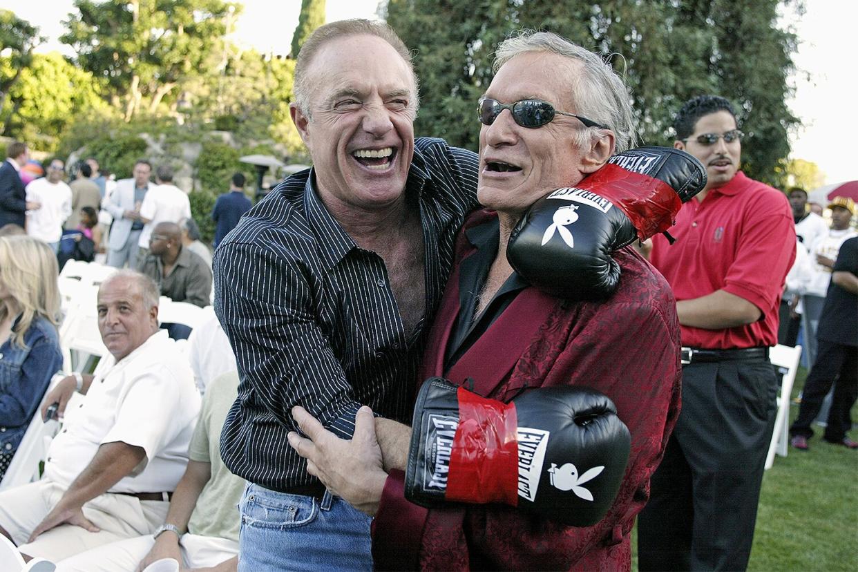 Actor James Cann and Playboy founder Hugh Hefner have a laugh during Fight Night at the Playboy Mansion on July 15, 2003 in Bel Air, California.