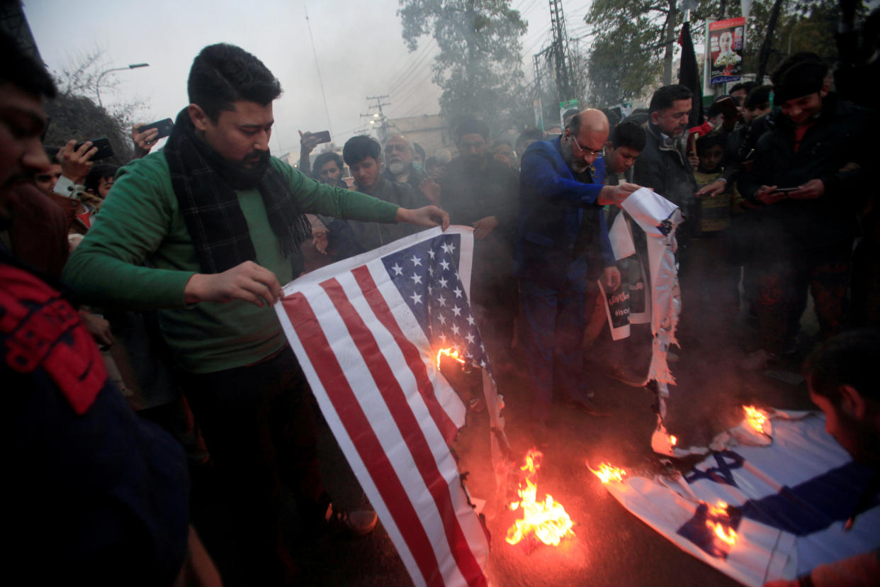 Pakistani Shi'ite Muslim supporters of Majlis-e-Wahdat-e-Muslimeen (MWM) burn U.S and Israel's flags to condemn the death of Iranian Major-General Qassem Soleimani, who was killed in an airstrike near Baghdad, during a protest in Lahore, Pakistan January 3, 2020. (Mohsin Raza/Reuters)