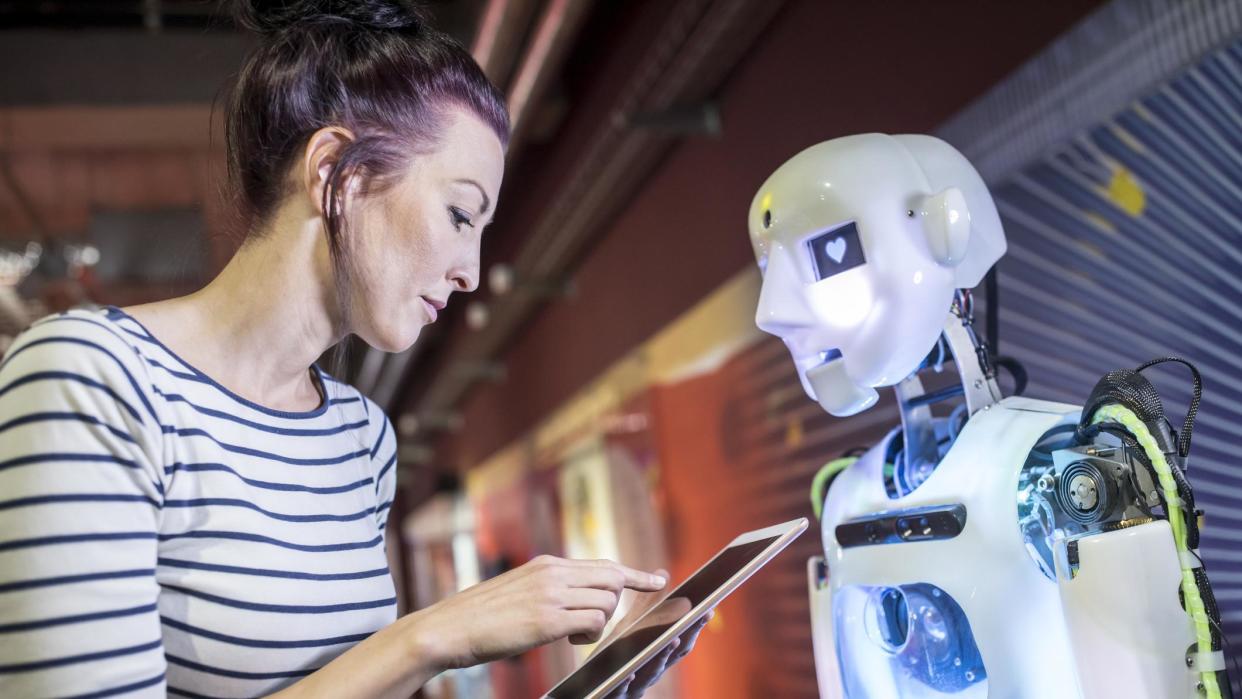 Una mujer junto a un robot