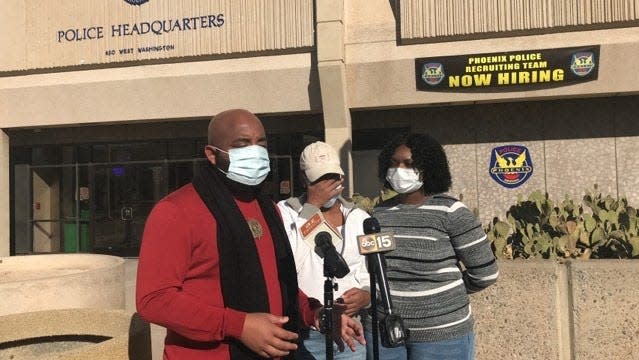 Community activist the Rev. Jarrett Maupin, Krystofer Lee and Iesha Stanciel address the news media during a press conference in front of Phoenix police headquarters in downtown Phoenix on Dec. 1, 2020.