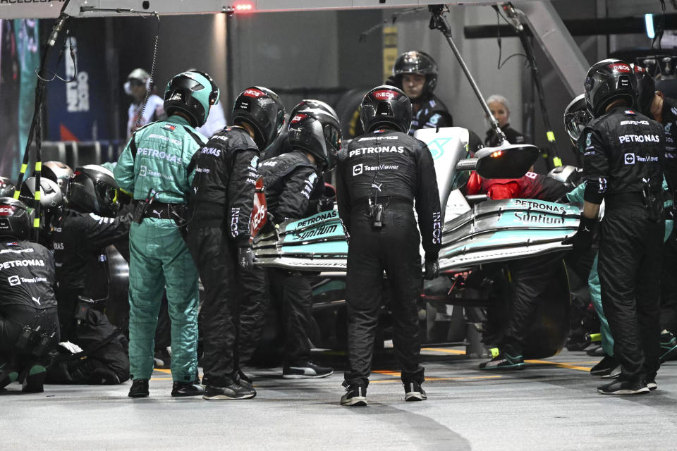 Mechanics change the front wing on Mercedes driver Lewis Hamilton of Britain's car during the Singapore Formula One Grand Prix, at the Marina Bay City Circuit in Singapore, Sunday, Oct. 2, 2022. (Mohd Rasfan/Pool photo via AP)