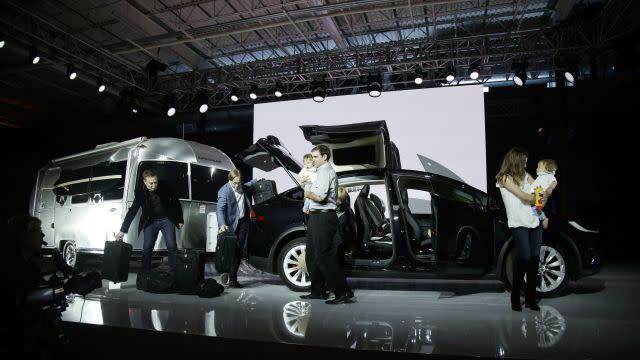 Elon Musk, CEO of Tesla Motors Inc., at left, shows the amount of cargo space on the new Model X car at the company's headquarters Tuesday, Sept. 29, 2015, in Fremont, Calif.