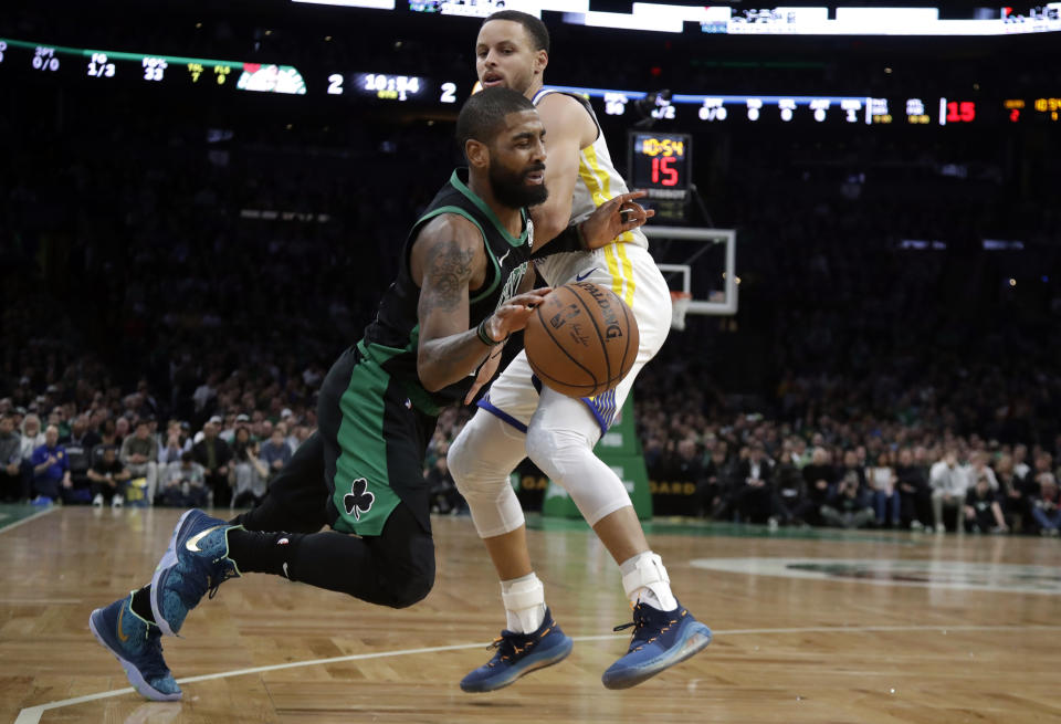 Boston Celtics guard Kyrie Irving, bottom, drives against Golden State Warriors guard Stephen Curry, top, in the first quarter of an NBA basketball game, Saturday, Jan. 26, 2019, in Boston. (AP Photo/Elise Amendola)
