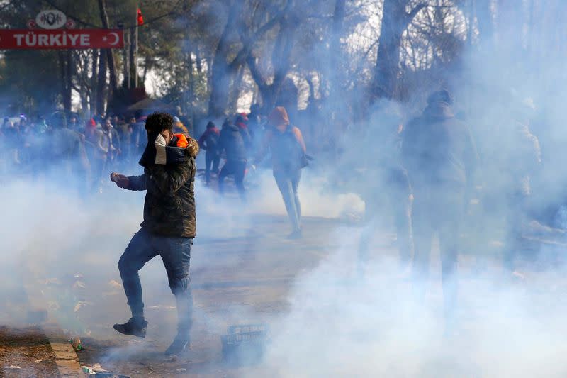 Un migrante cubre su rostro tras los disparos de gas lacrimógeno durante los enfrentamientos con la policía griega en la frontera entre Pazarkule y Kastanies, en Edirne, Turquía, el 29 de febrero de 2020