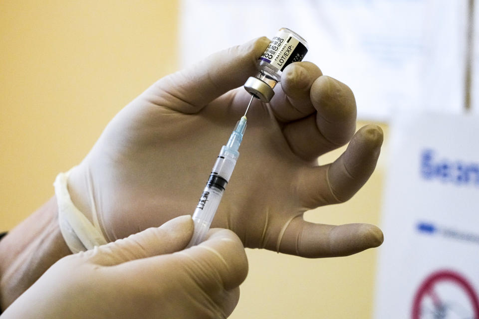 A medical nurse takes an anti-coronavirus vaccine with a syringe in a vaccination center in Morshyn, Ukraine, Tuesday, Nov. 16, 2021. In Morshyn, a scenic town nestled at the Carparthian foothills in the Lviv region, 74% of 3,439 residents have been fully vaccinated. A small spa town in western Ukraine stands out in a country where just under a quarter of the population has received coronavirus vaccines. (AP Photo/Efrem Lukatsky)