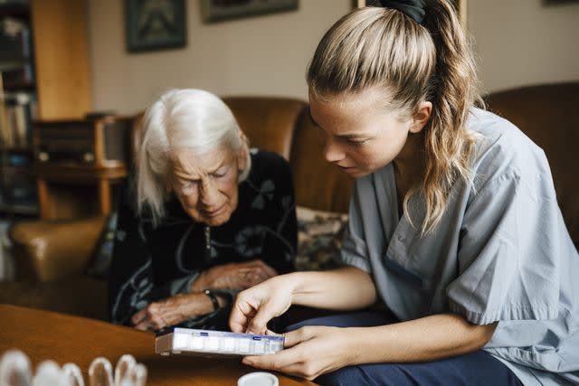 <p>Maskot / Getty Images</p> Female healthcare provider explaining medicine dose to older female at home