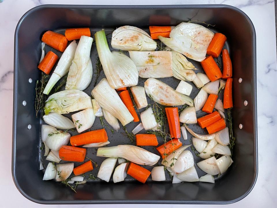 prepped vegetables in a roasting pan on a kitchen counter