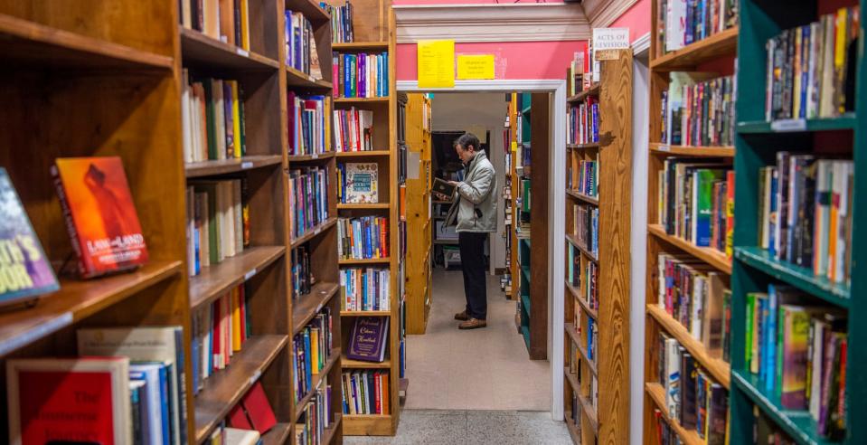 Nicholas Ehrgott looks over the selection of books  during the grand re-opening of Caveat Emptor on Friday, March 17, 2023.