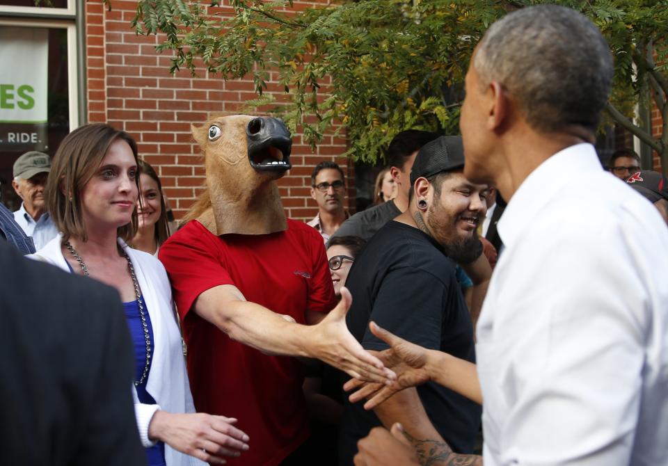 U.S. President Barack Obama greets a man wearing a horse mask during a walkabout in Denver July 8, 2014. Obama will speak about the economy at an event in Denver tomorrow. REUTERS/Kevin Lamarque (UNITED STATES - Tags: POLITICS ANIMALS TPX IMAGES OF THE DAY)