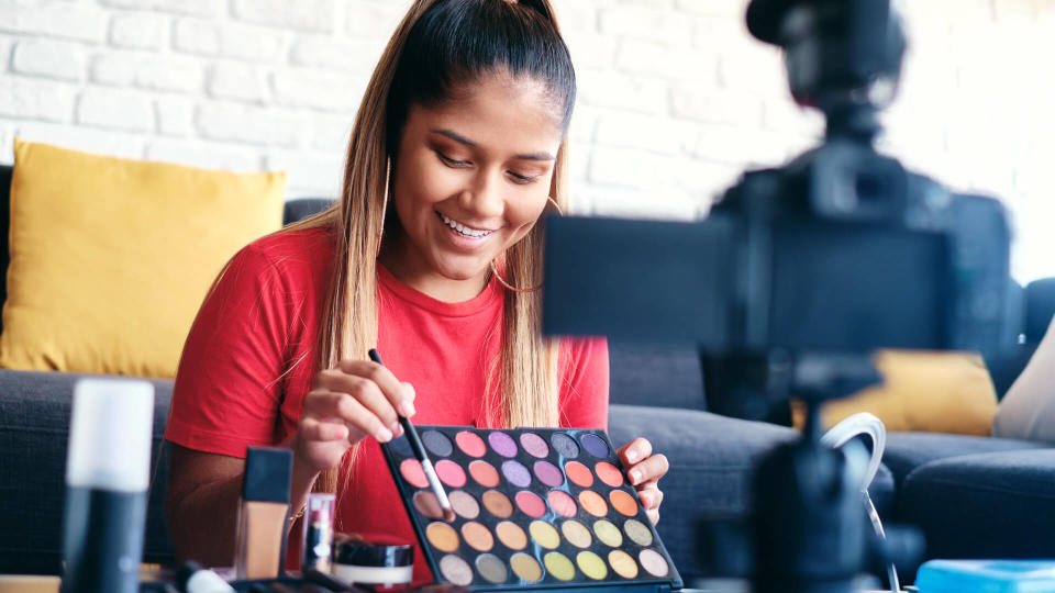 Happy girl at home speaking about make up in front of camera.