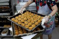 An employee takes a tray of mooncakes with anti-extradition bill slogans out of the oven at Wah Yee Tang Bakery in Hong Kong