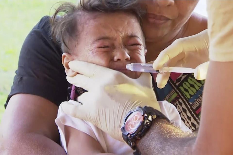 In this November 2019, image from video, a child gets vaccinated at a health clinic in Apia, Samoa. Samoa closed all its schools on Monday, Nov.18, 2019, banned children from public gatherings and mandated that everybody get vaccinated after declaring an emergency due to a measles outbreak. For the past three weeks, the Pacific island nation of 200,000 people has been in the grip of a measles epidemic that has been exacerbated by low immunization rates. (TVNZ via AP)