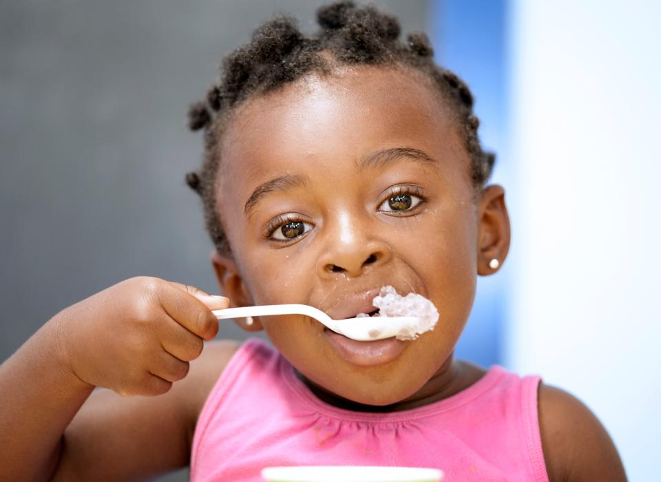 Brielle Kazadi, 2, eats grape-flavored shaved ice served from a Kona Ice truck, part of the Lancaster franchise, at the World of Wonderment day care center in Pataskala on Wednesday.