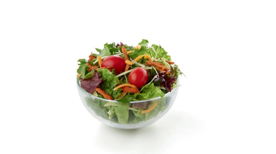 Chick-fil-A's side salad, which includes mixed greens, tomatoes, and cheese, appears against a white background.