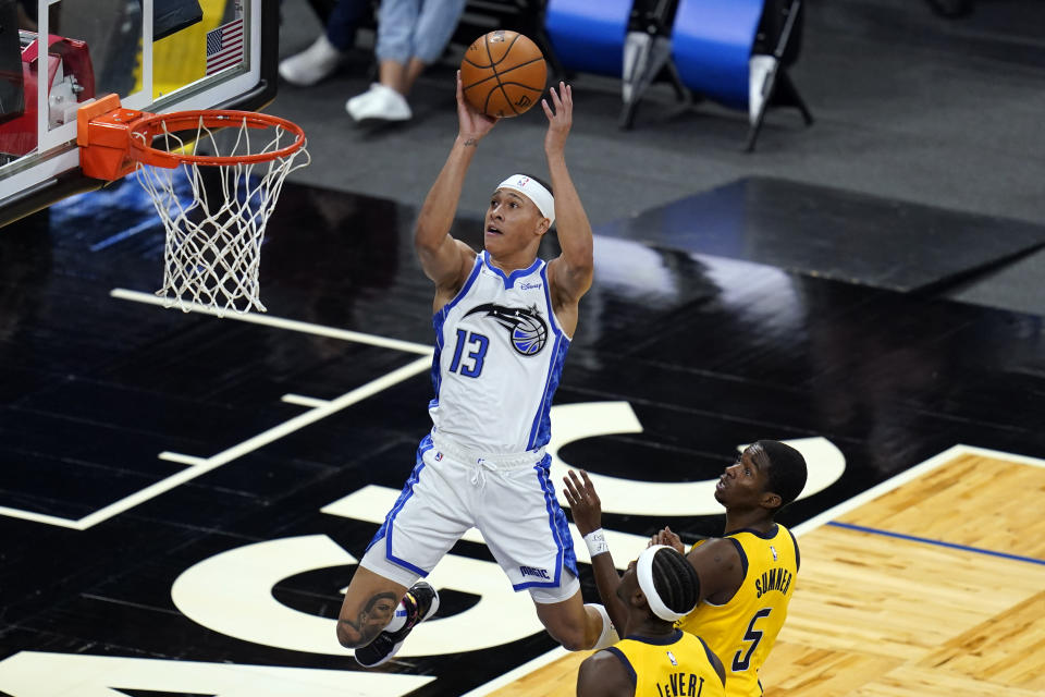 Orlando Magic guard R.J. Hampton (13) shoots over Indiana Pacers guard Caris LeVert, lower left, and guard Edmond Sumner (5) during the first half of an NBA basketball game, Friday, April 9, 2021, in Orlando, Fla. (AP Photo/John Raoux)