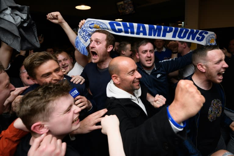 Leicester City fans celebrate winning the Premier League at the final whistle of the English Premier League football match between Chelsea and Tottenham Hotspur in a pub in central Leicester, England, on May 2, 2016