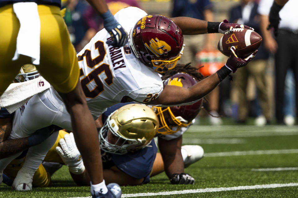 Central Michigan's Myles Bailey (26) reaches over Notre Dame's Howard Cross III (56) to score during the first half of an NCAA college football game on Saturday, Sept. 16, 2023, in South Bend, Ind. (AP Photo/Michael Caterina)