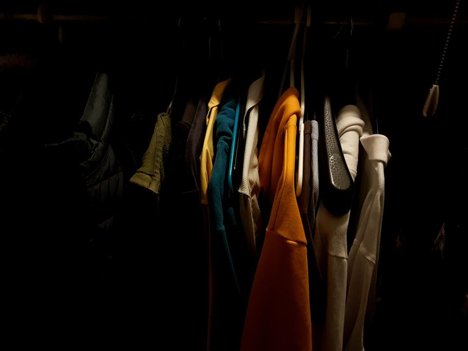 Clothes Hanging On Rack In Darkroom