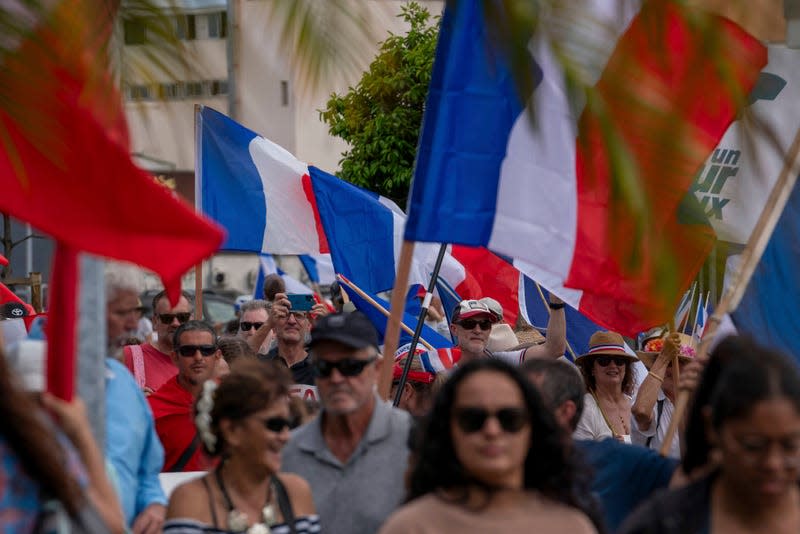Demonstrators from several loyalist parties wave French national flags as they march during a demonstration to support the enlargement of the electorate for the forthcoming provincial elections in New Caledonia, in Noumea, on April 13, 2024. - Photo: Nicolas Job/SIPA (AP)