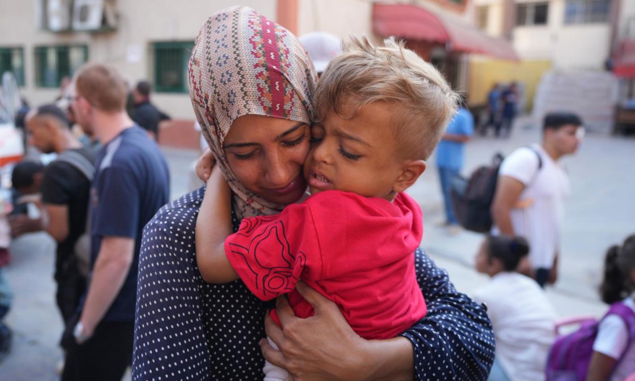 <span>A Palestinian woman says goodbye to her sick son on Thursday before he leaves the Gaza Strip through the Kerem Shalom crossing to get treatment abroad.</span><span>Photograph: Abdel Kareem Hana/AP</span>