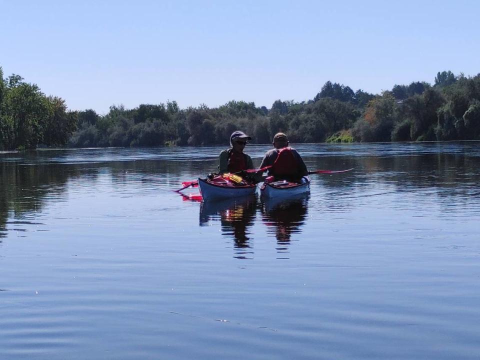 A pair of kayakers pause to enjoy the scenery along the lower Yakima River in Richland on a sunny Tri-Cities day.