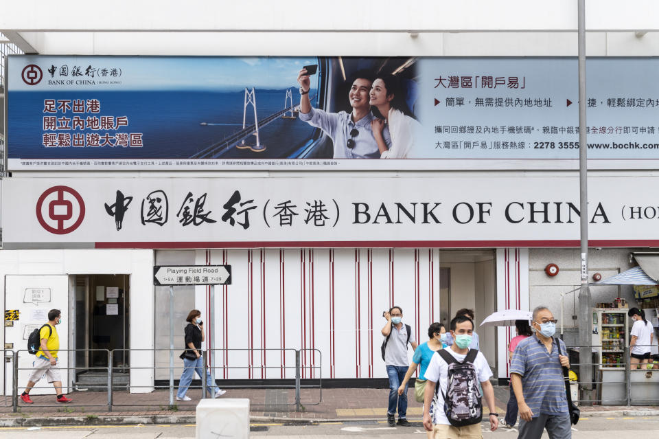 HONG KONG, CHINA - 2020/07/17: Pedestrians wearing face masks walk past a Chinese state-owned commercial banking company Bank of China branch in Hong Kong. (Photo by Budrul Chukrut/SOPA Images/LightRocket via Getty Images)