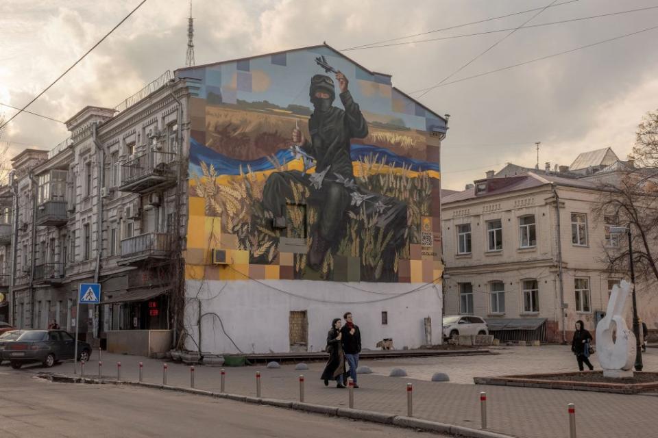 People walk past a mural in Kyiv's Podil neighbourhood, on Feb. 22, 2024, ahead of the second anniversary of Russia's invasion of Ukraine.<span class="copyright">Roman Pilipey—AFP/Getty Images</span>