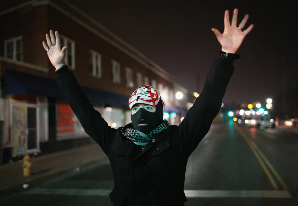 Demonstrators protest in front of the police station on March 12, 2015 in Ferguson, Missouri. Two police officers were shot yesterday while standing outside the station observing a similar protest. Ferguson has faced many violent protests since the August shooting death of Michael Brown by a Ferguson police officer.