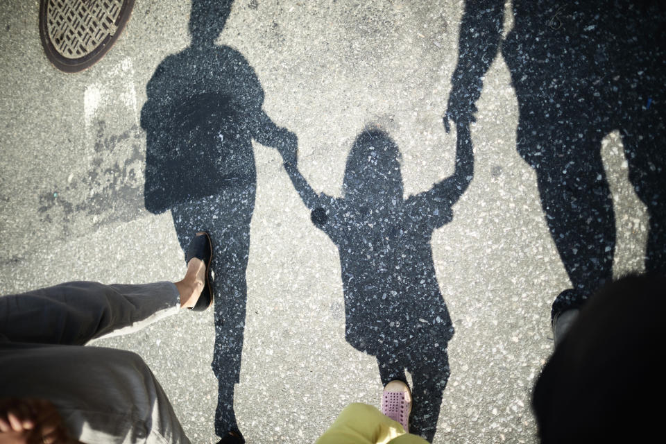 family's shadow as they hold hands and walk