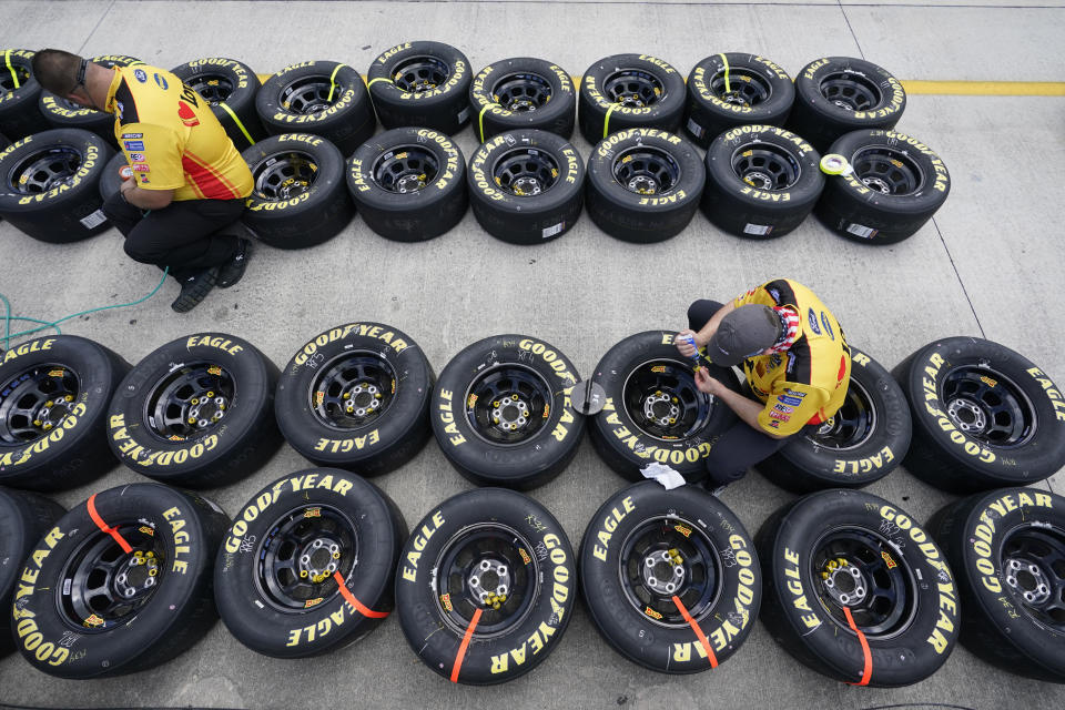 Crew members for Michael McDowell (34) work on tires before the start of a NASCAR Cup Series auto race, Sunday, Feb. 28, 2021, in Homestead, Fla. (AP Photo/Wilfredo Lee)