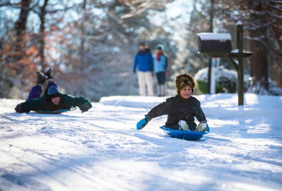 Jaan Ewing, 7, sleds down N. Boundary St. ahead of Max Winzelberg, 17, in Chapel Hill, N.C. on Saturday, Jan. 22 2022.