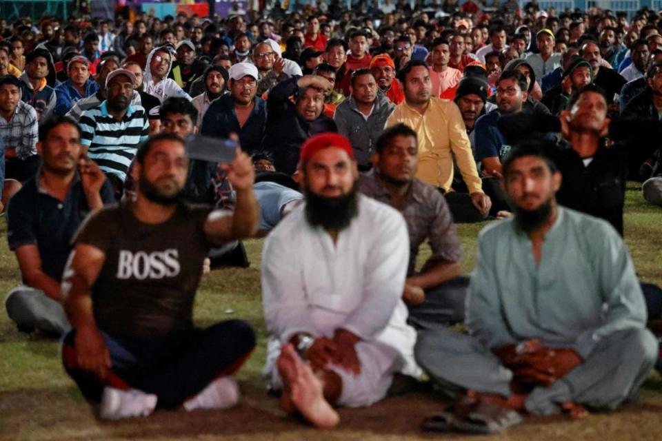 Migrant workers watch the World Cup match between Spain and Germany on the outskirts of Doha (AFP via Getty Images)