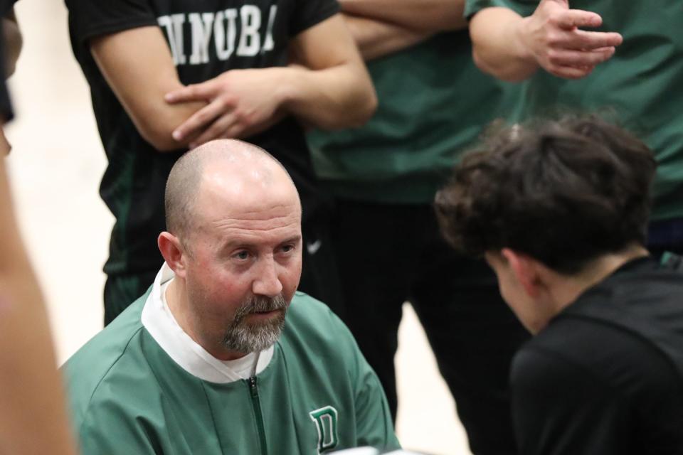 Dinuba head coach Jeff Schofield talks to his players during a timeout against Redwood in a non-league high school boys basketball game on Tuesday, December 12, 2023.