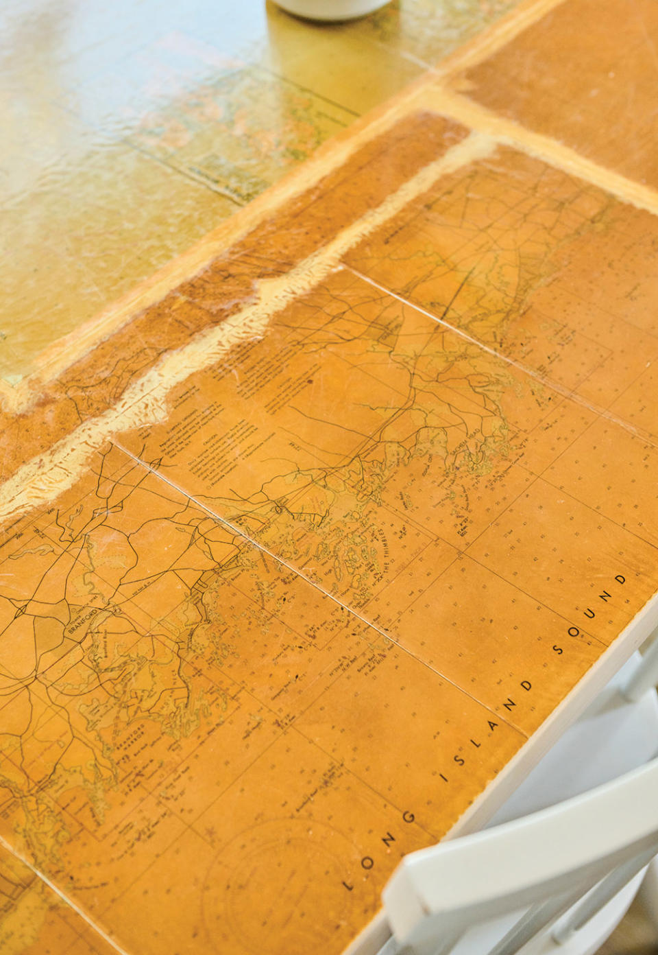 Decor in the beach house includes (from left) a dining table depicting the Eastern Seaboard (where the home’s inhabitants grew up)