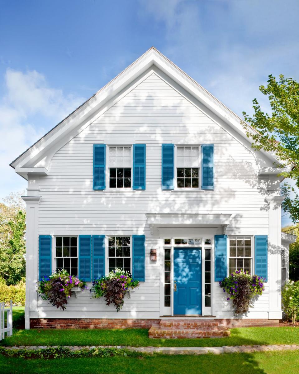 classic white colonial house with blue shutters and front door