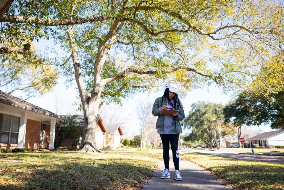 Lauren Ashley Simmons checks addresses of voters as she block walks on in Houston.
