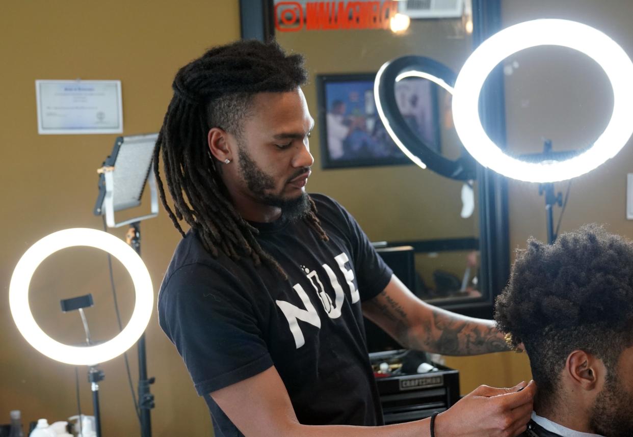 Barber and college student Wallace Welch cuts a customer's hair while talking about his concerns as a young voter during the 2024 presidential election in Chattanooga, Tennessee.