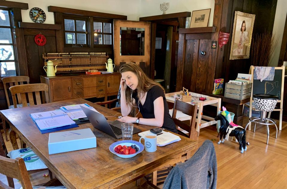 Martha Lackritz-Peltier, attorney at TechSoup, talks to one of her colleagues over the phone while working from her living room in Oakland, California, March 12, 2020. - Martha Lackritz-Peltier, an attorney at nonprofit group TechSoup, is working from her home in Oakland, where her companions include two dogs and hummingbirds flitting about the garden. (Photo by Julie JAMMOT / AFP) (Photo by JULIE JAMMOT/AFP via Getty Images)