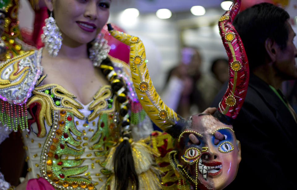 A contestant holds her mask as she waits to compete in the Queen of Great Power contest, in La Paz, Bolivia, Friday, May 24, 2019. The largest religious festival in the Andes choses its queen in a tight contest to head the Festival of the Lord Jesus of the Great Power, mobilizing thousands of dancers and more than 4,000 musicians into the streets of La Paz. (AP Photo/Juan Karita)