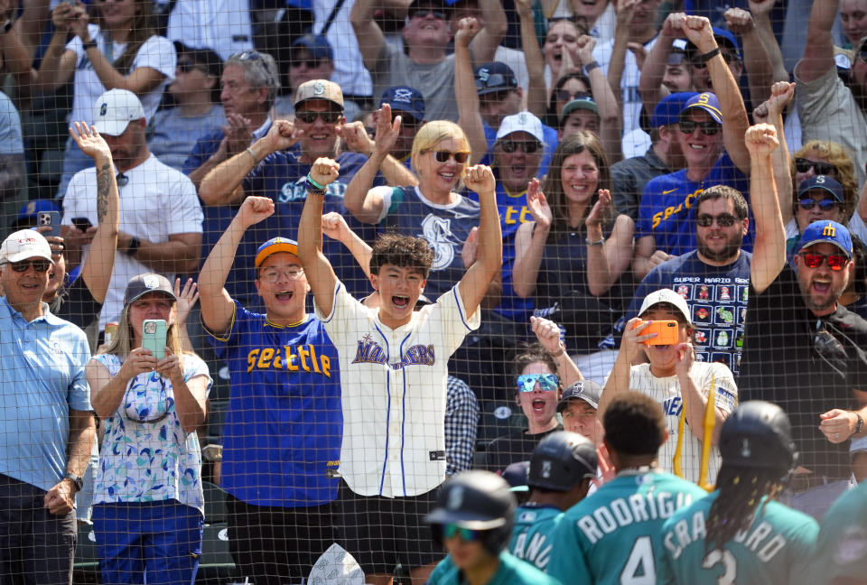 Fans cheer as Seattle Mariners' Teoscar Hernandez walks back to the dugout after hitting a grand slam against the Kansas City Royals during the third inning of a baseball game Saturday, Aug. 26, 2023, in Seattle. (AP Photo/Lindsey Wasson)